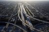 Vehicles drive in light traffic on the Judge Harry Pregerson Interchange between the 105 and 110 freeways in this aerial photograph taken above Los Angeles, California, U.S., on Friday, May 1, 2020. California Governor Gavin Newsom is directing departments to cut spending immediately amid projected deficits of $35 billion, while Los Angeles Mayor Eric Garcetti proposed a budget that calls for civilian workers to take 26 furlough days during the fiscal year that begins in July.