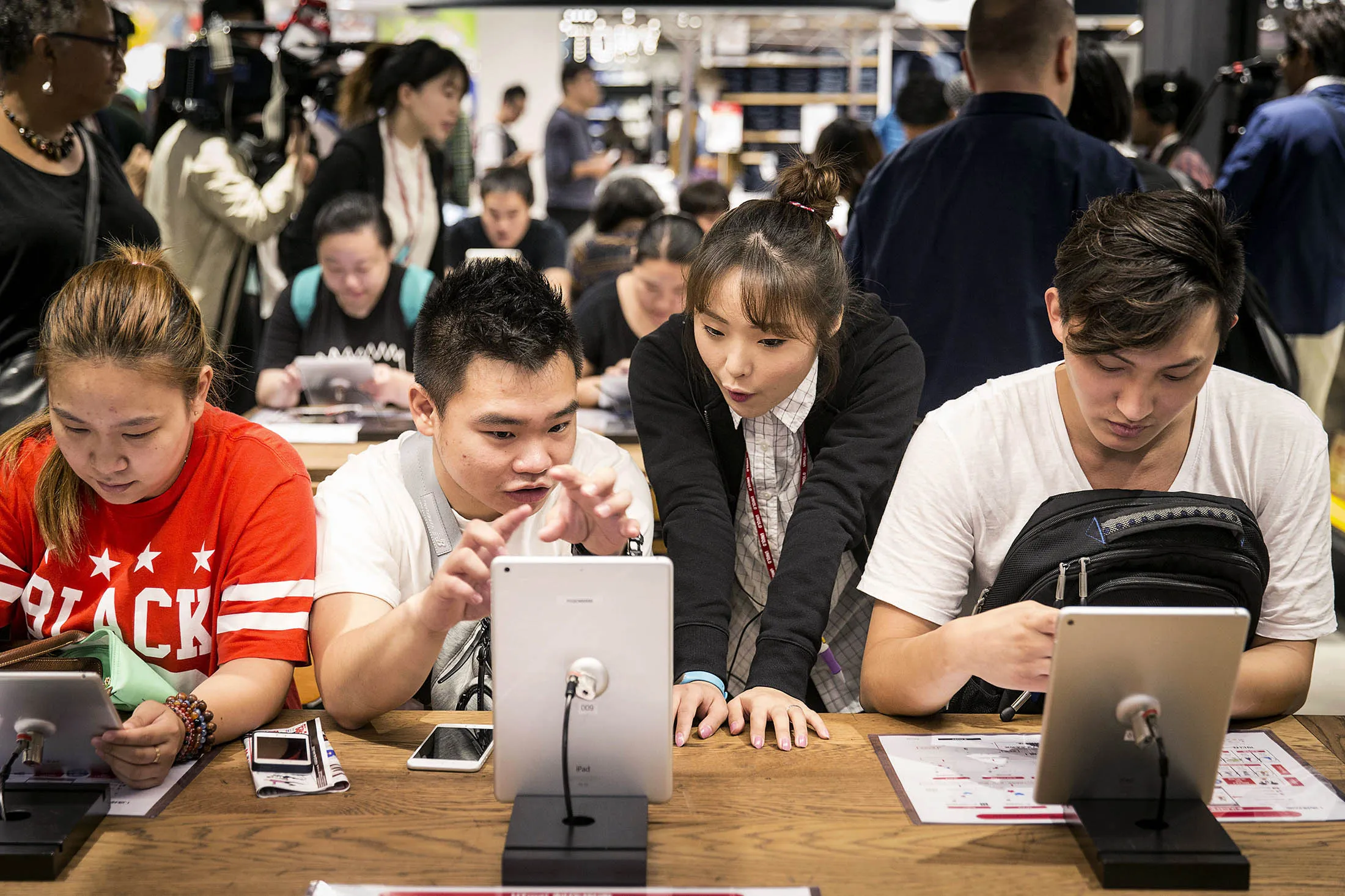 Customers use tablets to design their own T-shirts at a Uniqlo store in Shanghai.

