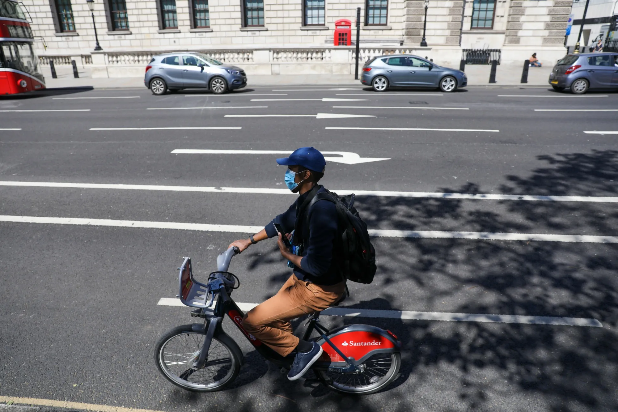 A cyclist using a Santander Cycle hire bike travels in a cycle lane in London.