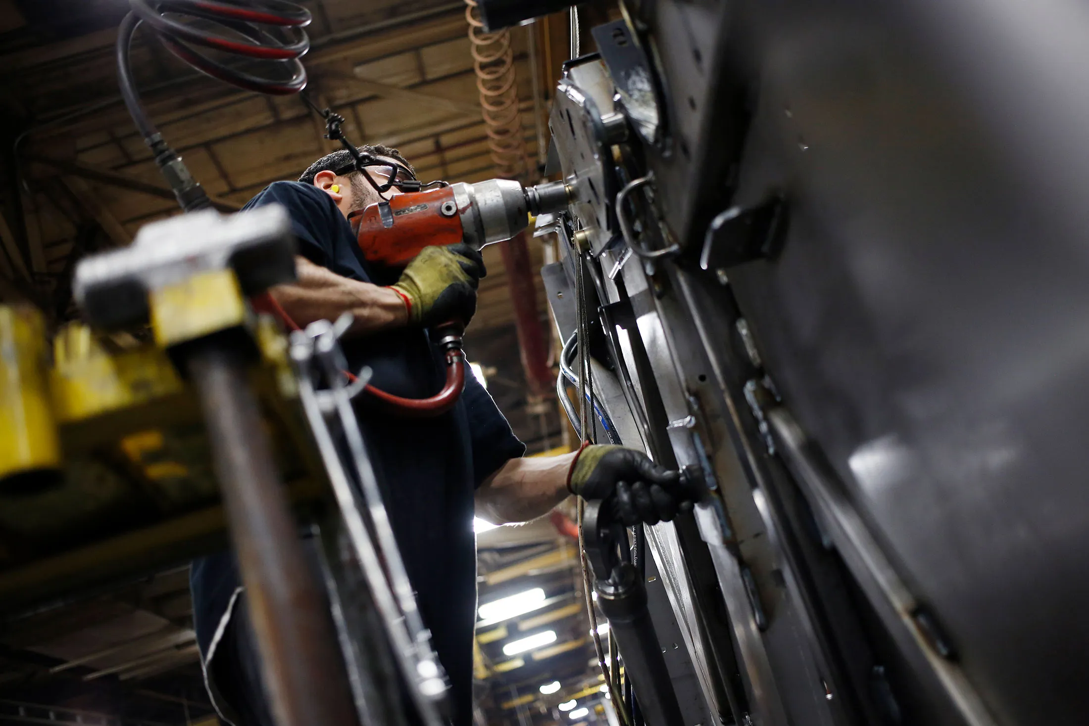A worker installs components onto a round baler at a factory in New Holland, Pennsylvania.
