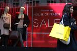 A shopper passes a House of Fraser Ltd. department store window in London.