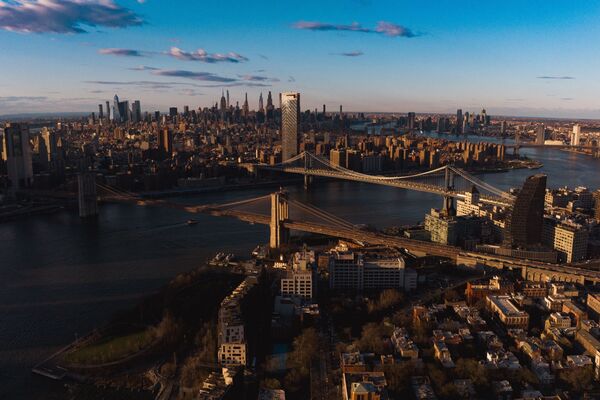 Sunset dusk on NYC Skyline from Brooklyn view over East River and Manhattan features on Brooklyn Bridge