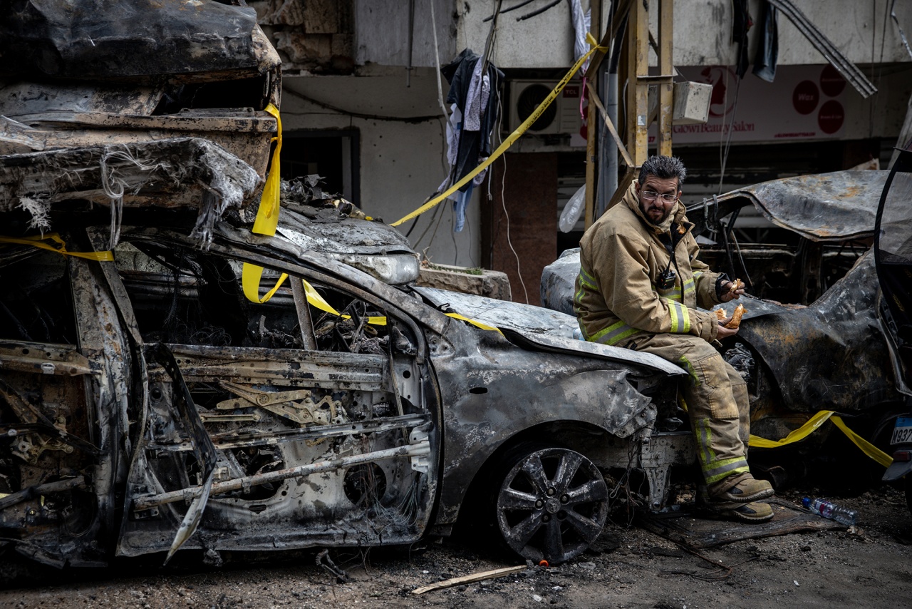 A firefighter takes a break on a vehicle destroyed in an airstrike in Beirut on April 9. Photographer: Chris McGrath/Getty Images