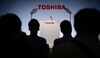 Journalists sit in front of a logo of Toshiba prior to the company's press conference in Tokyo.