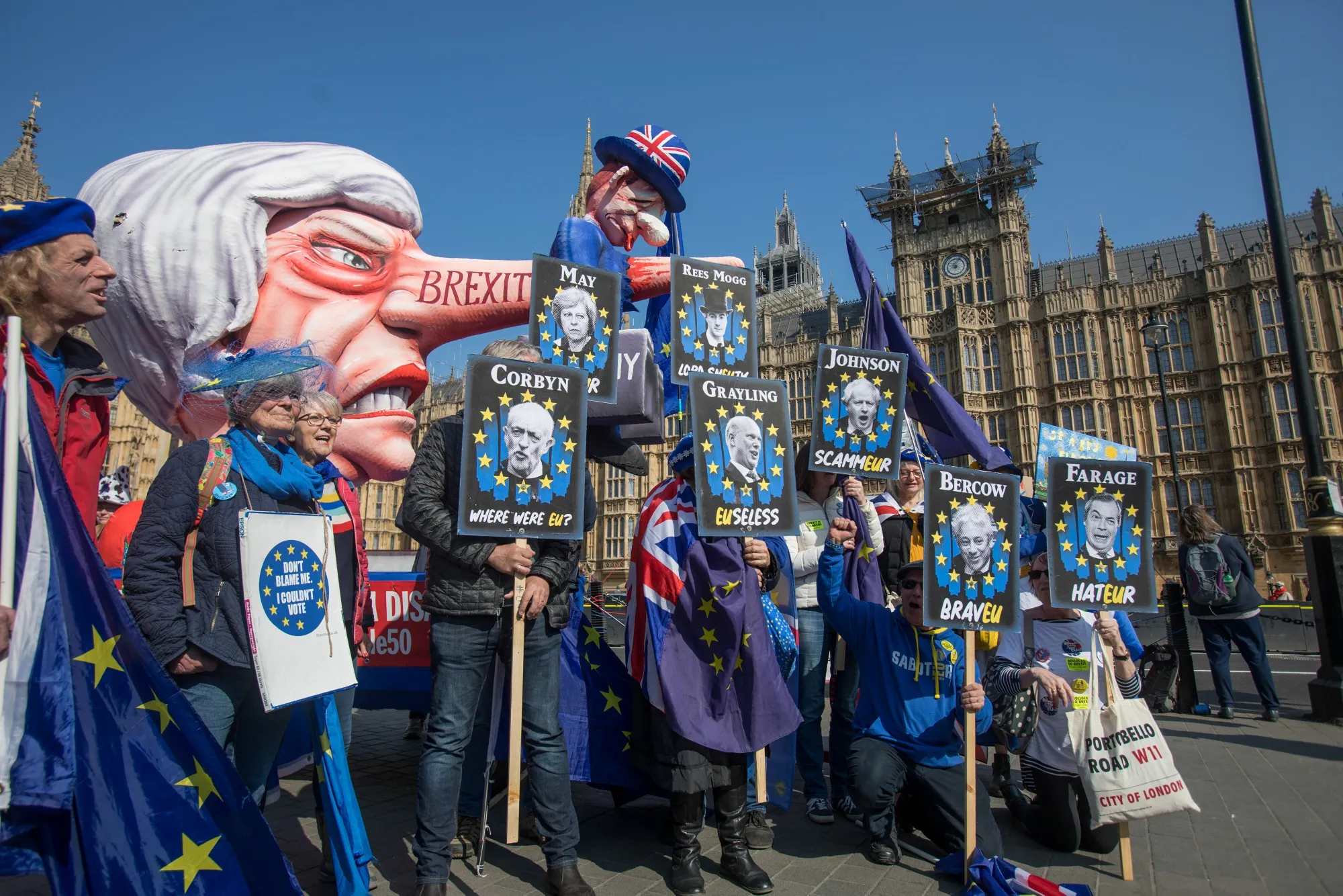 Anti-Brexit protesters stand near a satirical sculpture of U.K. Prime Minister Theresa May&nbsp;near the Houses of Parliament in London.