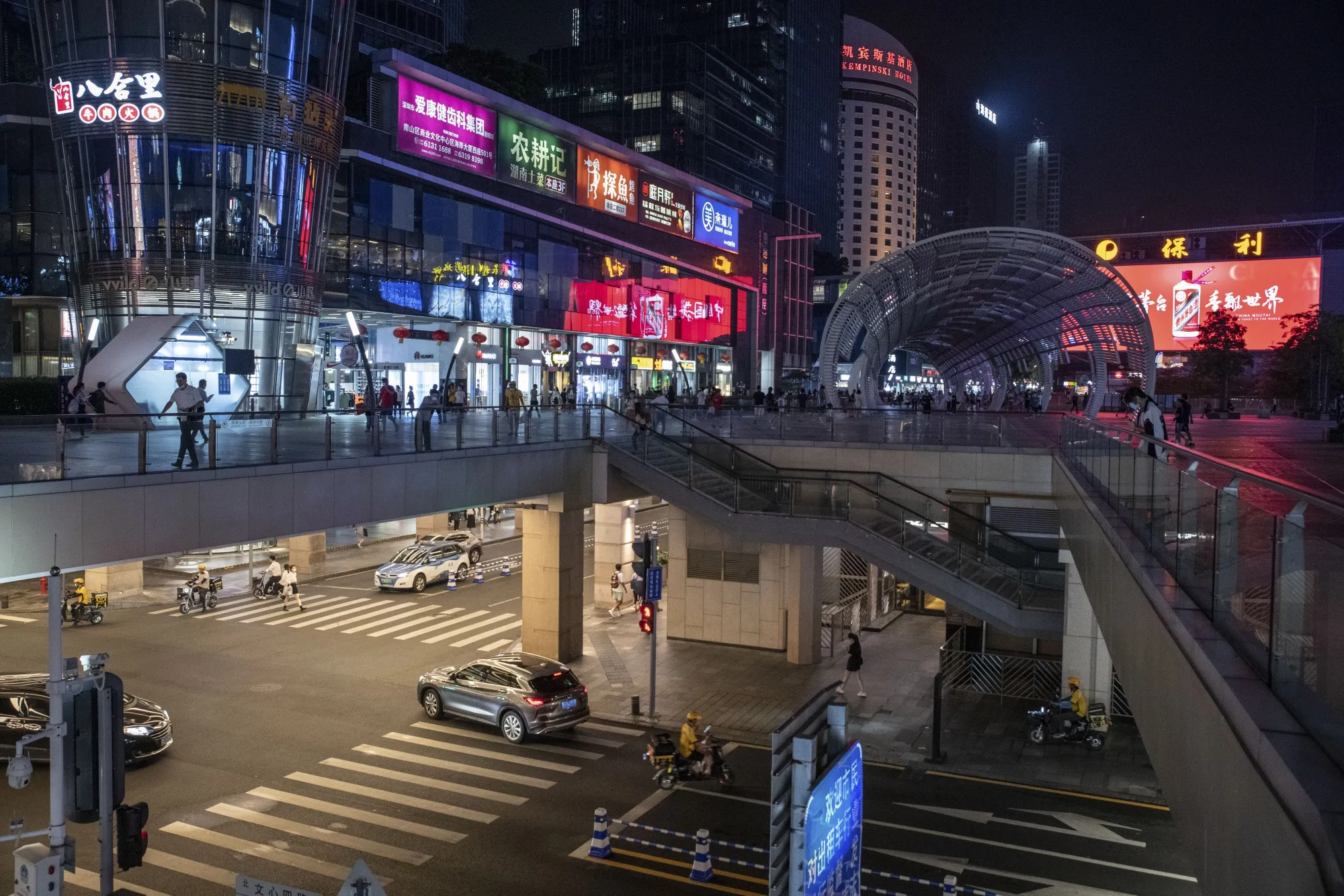 Pedestrians and traffic&nbsp;outside a mall in Shenzhen.