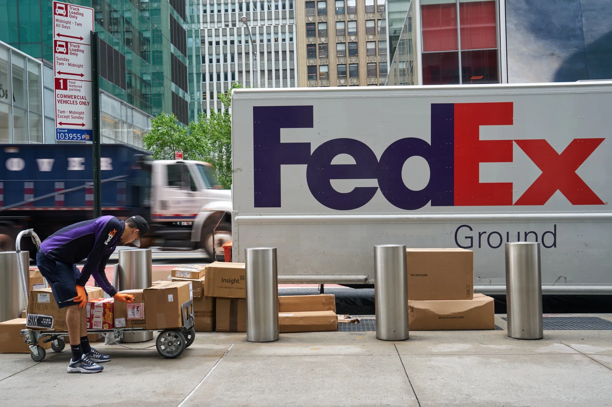 A&nbsp;FedEx worker unloads packages from a delivery truck in New York.