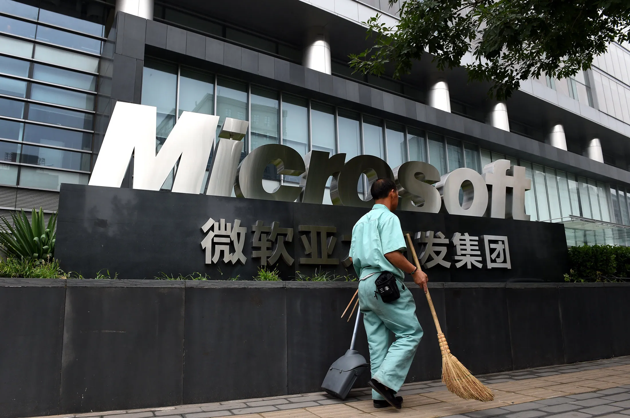 A worker walks past a Microsoft office building in Beijing, on July 31, 2014.
