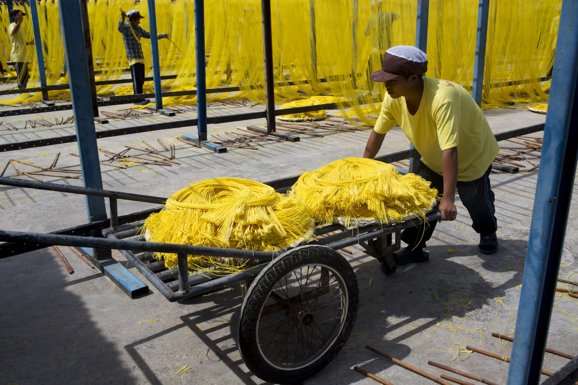 A worker pushes a cart of sun-dried noodles at a&nbsp;noodle factory in the Ban Pong district of Ratchaburi province, Thailand.