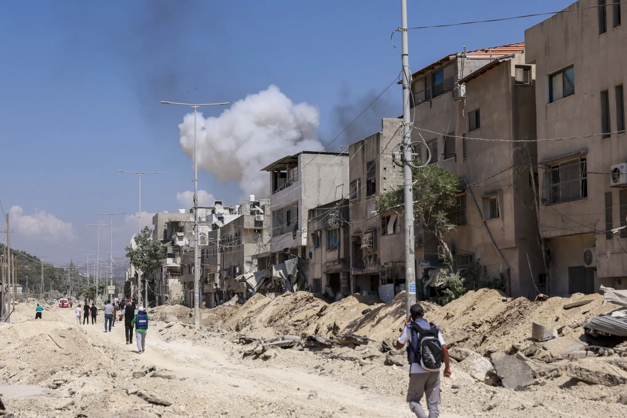 People walk along a heavily damaged street in the occupied West Bank on July 9.