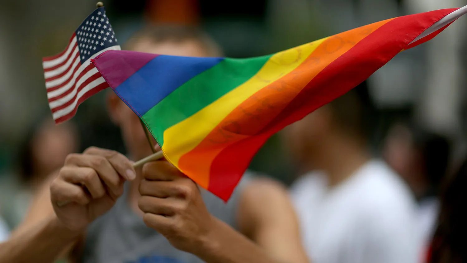 A protester holds an American flag and rainbow flag in front of the Miami-Dade Courthouse to show his support of the LGBTQ couples inside the courthouse were asking the state of Florida to recognize their marriage on July 2, 2014 in Miami, Florida. Six couples that identify as Lesbian, Gay, Bisexual, Transgender and Queer (LGBTQ) are in court asking that their same-sex marriage be recognized in the state of Florida.
