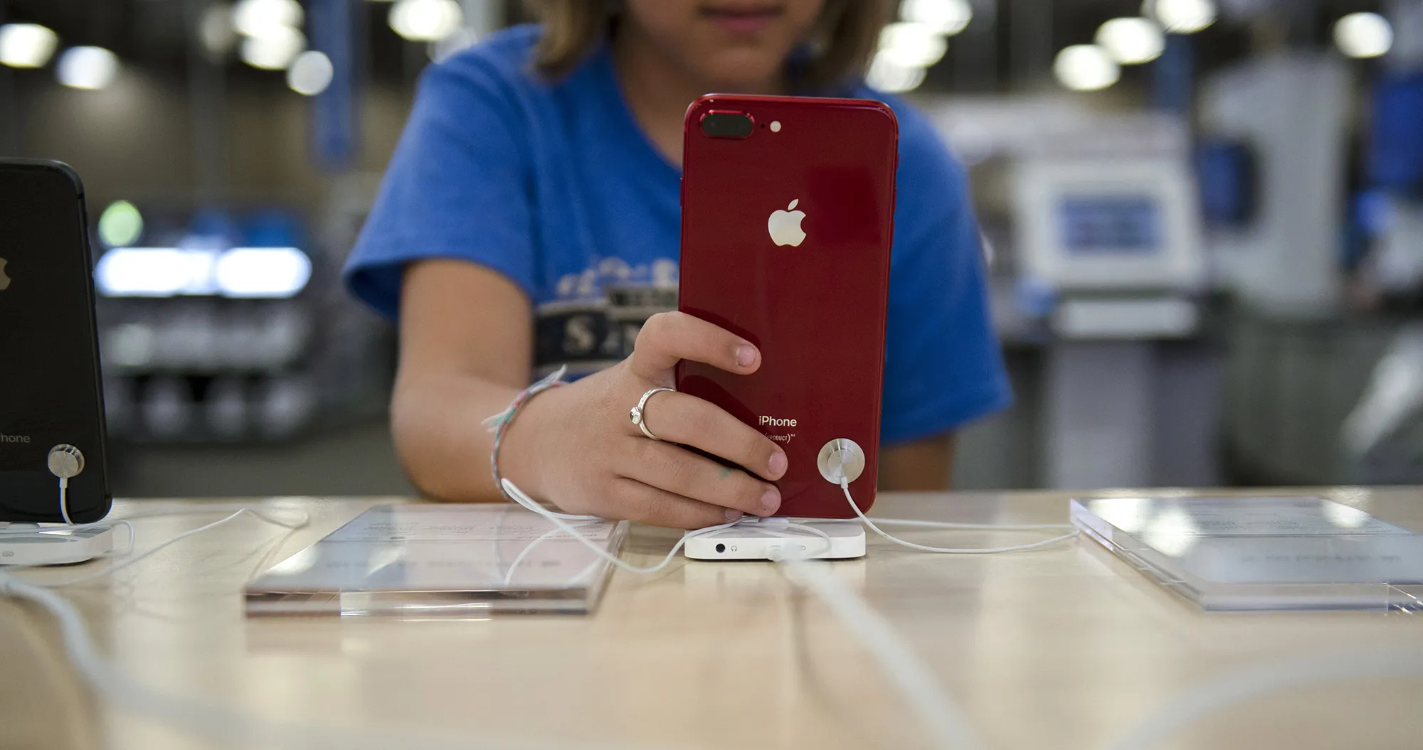 A customer views an Apple Inc. iPhone on display for sale at a store in San Antonio, Texas.