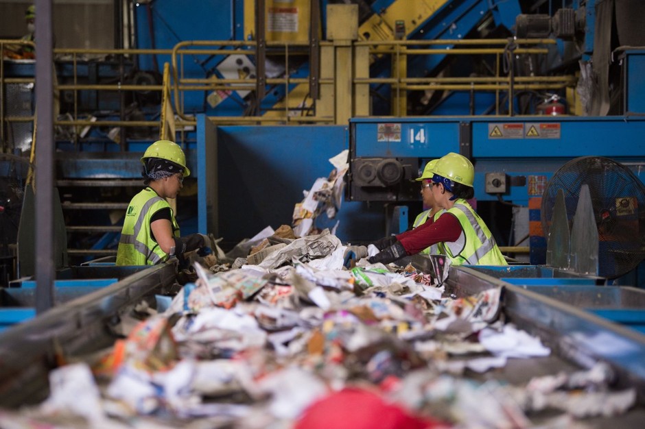 Workers sort recycling material at the Waste Management Material Recovery Facility in Elkridge, Maryland, in June 2018.