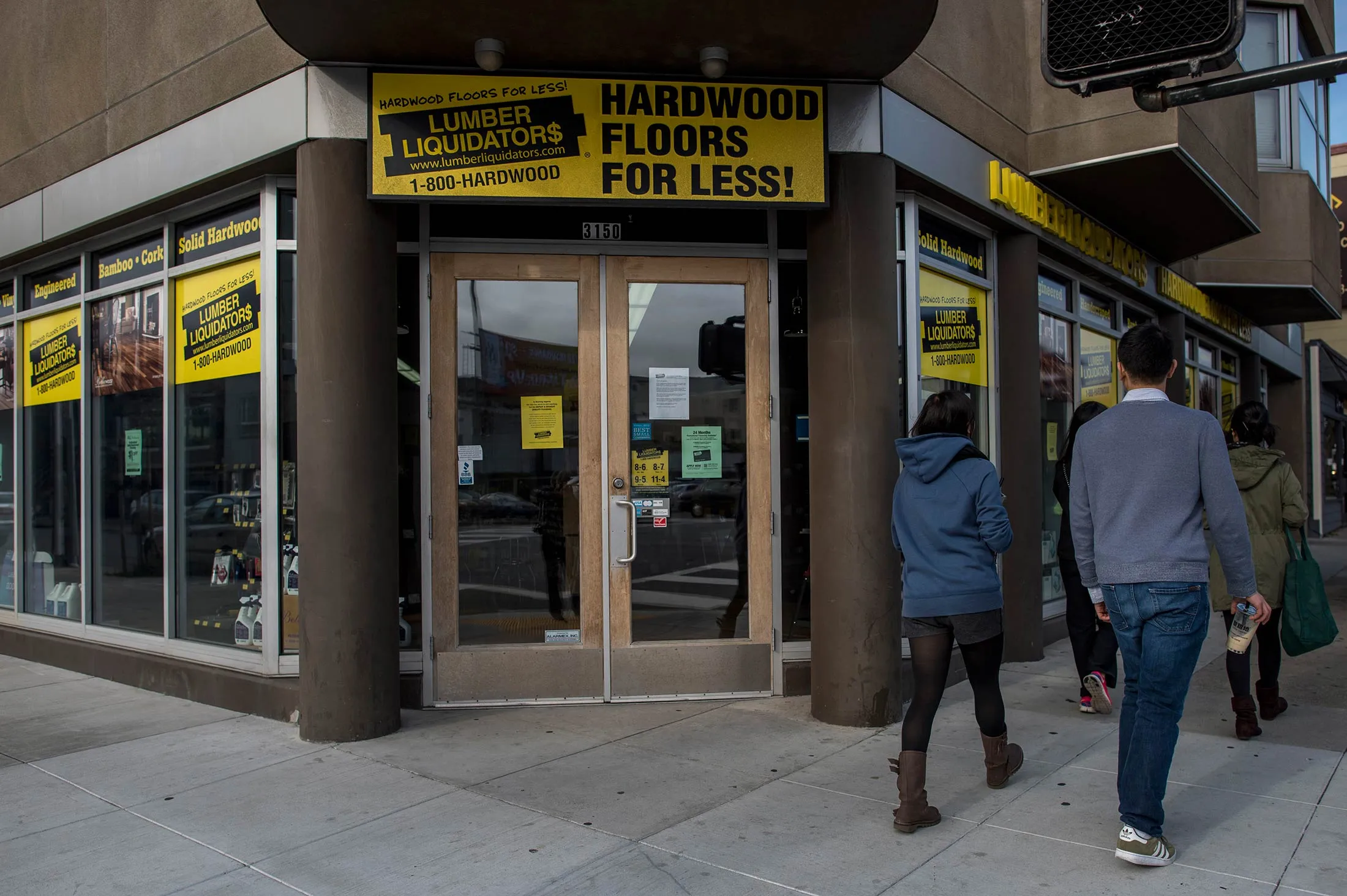 Pedestrians walk in front of a Lumber Liquidators store in San Francisco.
