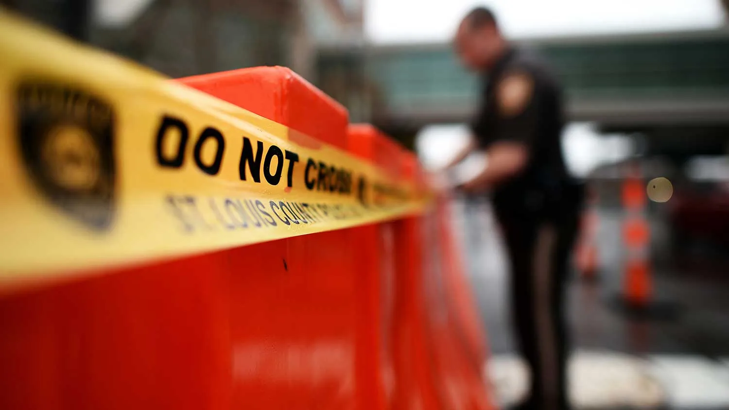 A police officer puts do not cross tape on barricades around the Buzz Westfall Justice Center in Clayton, Missouri, on November 23, 2014 where a grand jury has been considering whether to indict a white Ferguson police officer who shot and killed 18-year-old black teenager Michael Brown.
