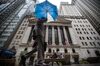 A pedestrian holding an umbrella passes in front of the New York Stock Exchange (NYSE) in New York, U.S., on Thursday, Oct. 11, 2018.