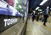 Pedestrians walk past a Toshiba Corp. advertisement in Tokyo, Japan, on Tuesday, March 14, 2017. Toshiba is considering the sale of a majority stake in its Westinghouse nuclear unit as the company grapples with construction delays and a multibillion dollar writedown in the business.