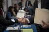 A representative, left, shakes hands with a job seeker at the San Francisco Career Fair & Job Fair in Burlingame, California, U.S., on Thursday, March 14, 2019. The Department of Labor is scheduled to release initial jobless claims figures on March 21.