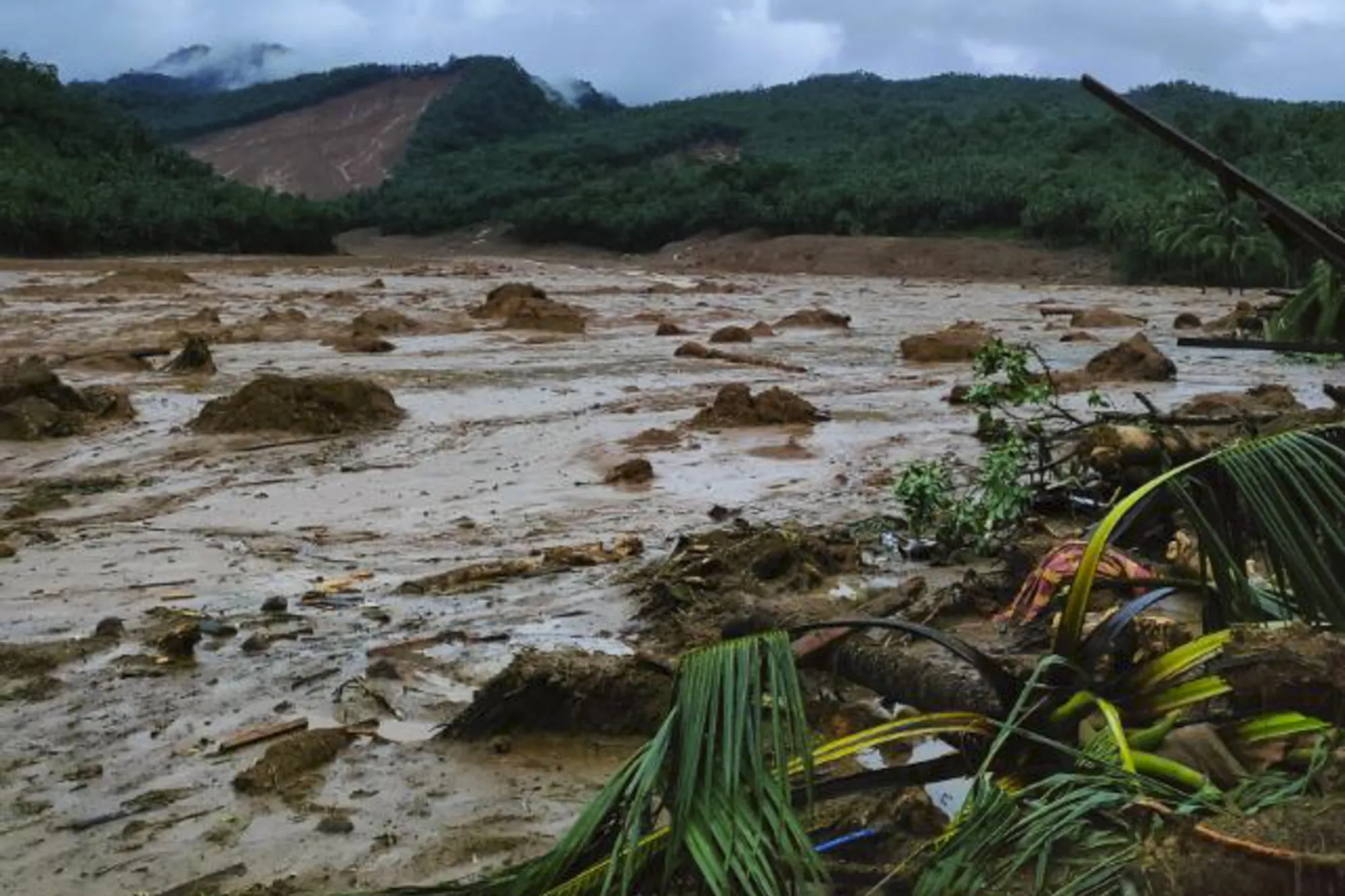 This photo provided by the Philippine Coast Guard, shows a landslide area at Baybay City, Leyte province, central Philippines Monday, April 11, 2022. Heavy rains caused by a summer tropical depression killed at least several people in the central and southern Philippines, mostly due to landslides, officials said Monday. (Philippine Coast Guard via AP)