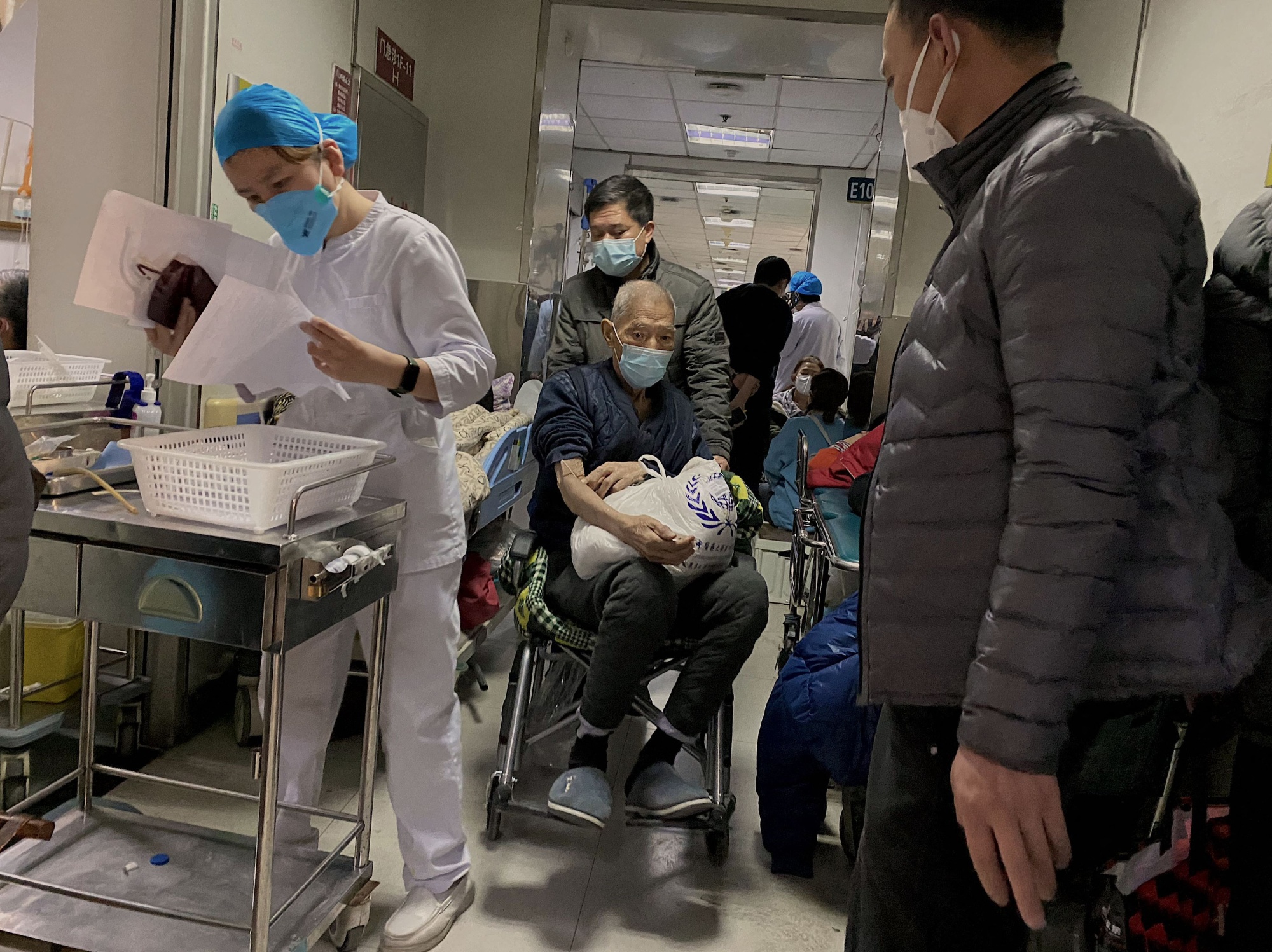 A Covid-19 patient being moved on a wheelchair at Tianjin First Center Hospital in Tianjin, China.&nbsp;Cities across China have struggled with surging infections, a resulting shortage of pharmaceuticals and overflowing hospital wards and crematoriums after Xi Jinping suddenly dismantled his “Covid zero” lockdown and testing regime.&nbsp;