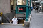 A commuter wearing a protective mask exits from the Wall Street subway station in New York.