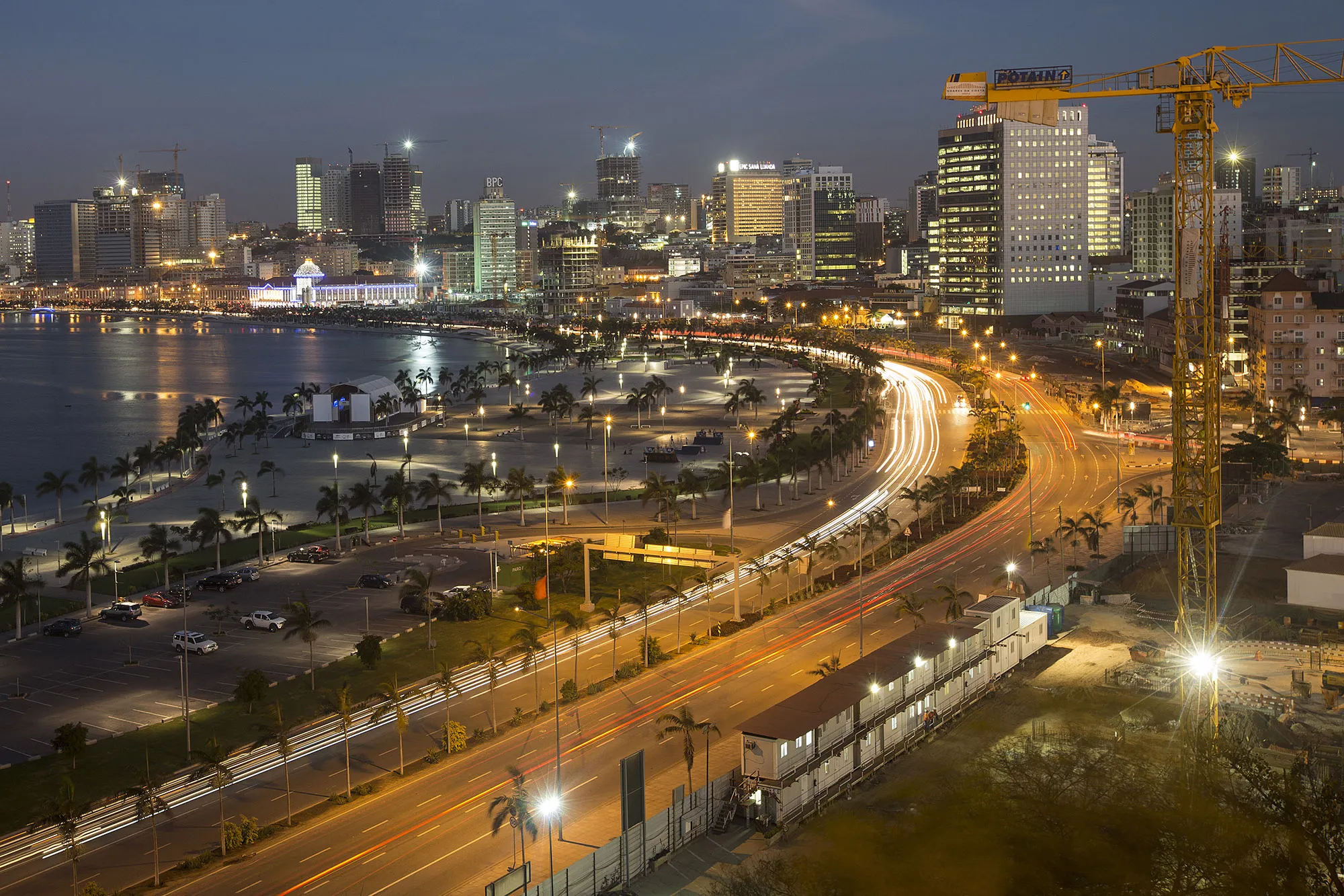Traffic passes beneath a construction crane in Luanda, Angola.