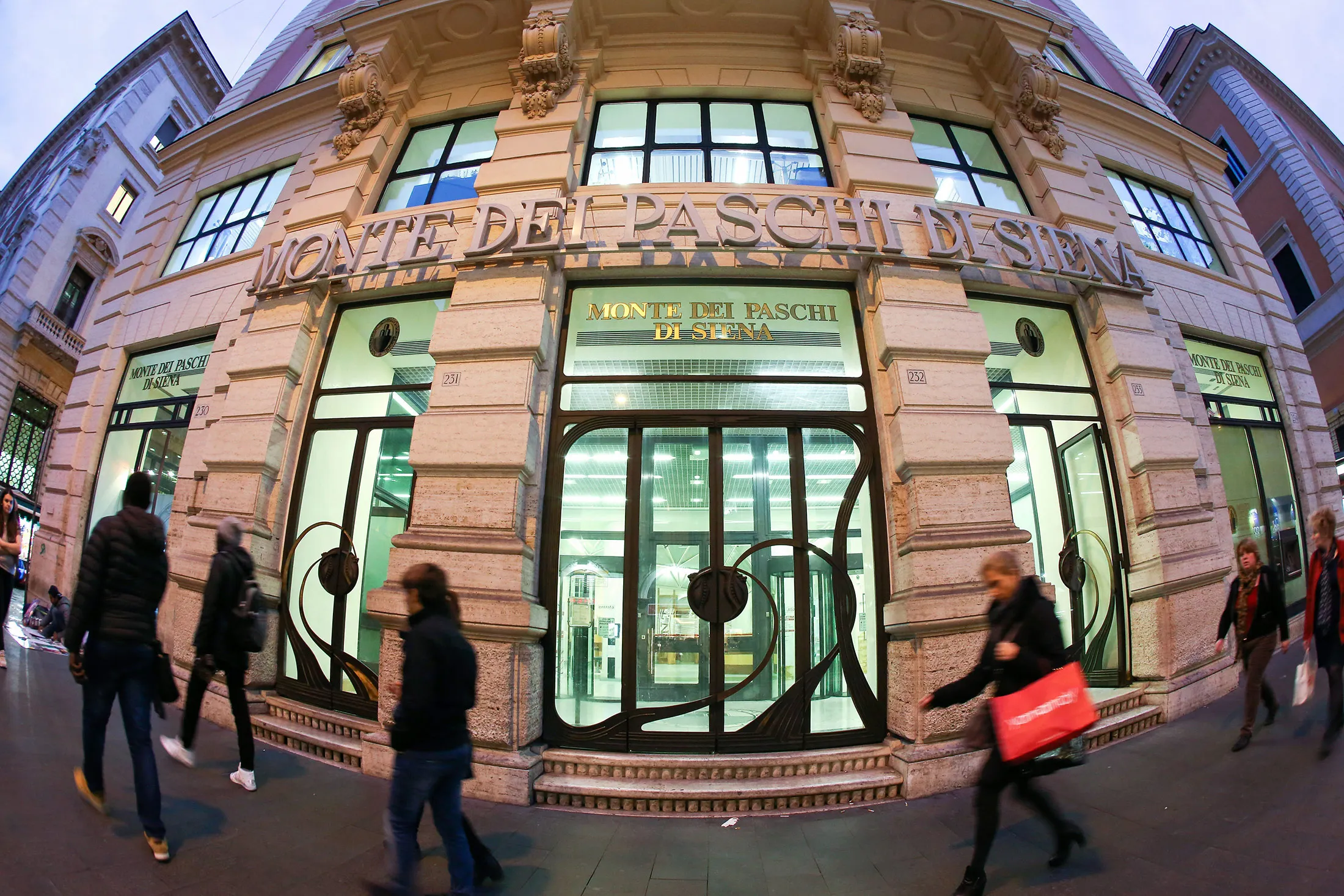 Pedestrians pass a Banca Monte dei Paschi di Siena SpA bank branch in Rome.
