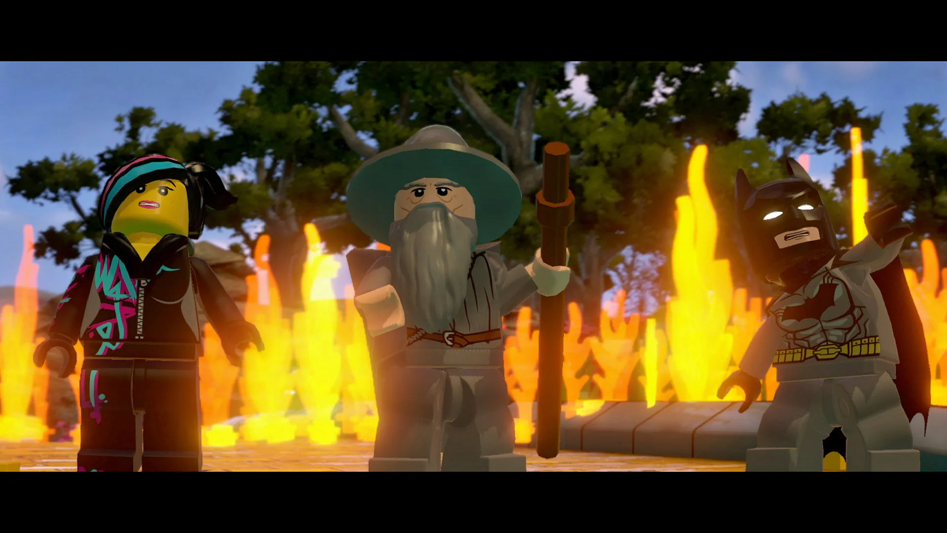 Hero characters Wyldstyle, left, Gandalf, center, and Batman, stand on the Yellow Brick Road during the gameplay in the Lego Dimensions video game.
