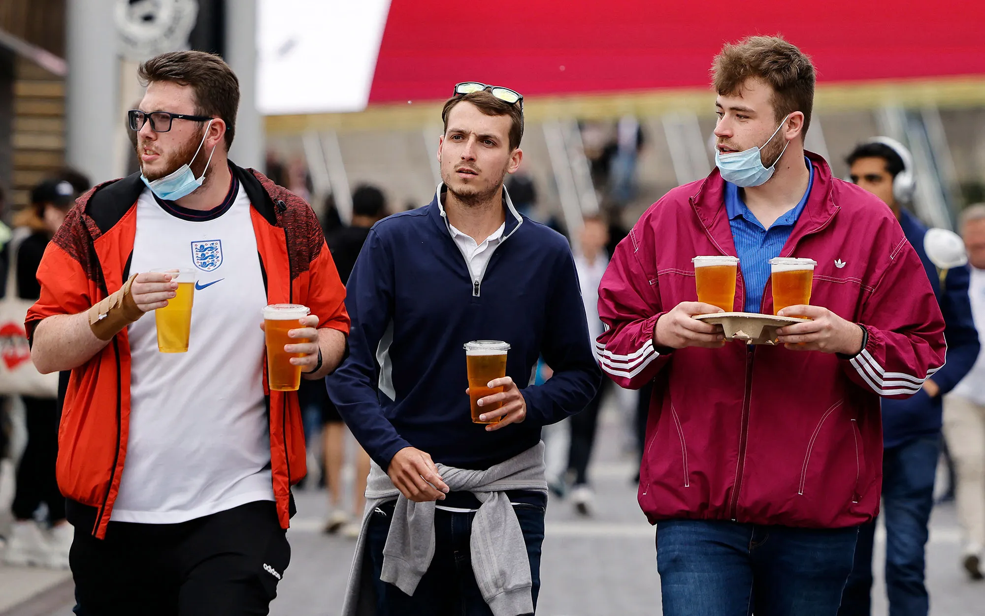 England supporters carry pints of beer as they arrive at Wembley Stadium.&nbsp;