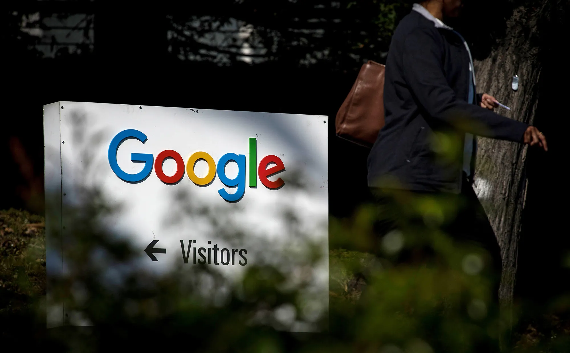 A pedestrian walks past signage at Google Inc. headquarters in Mountain View, California.