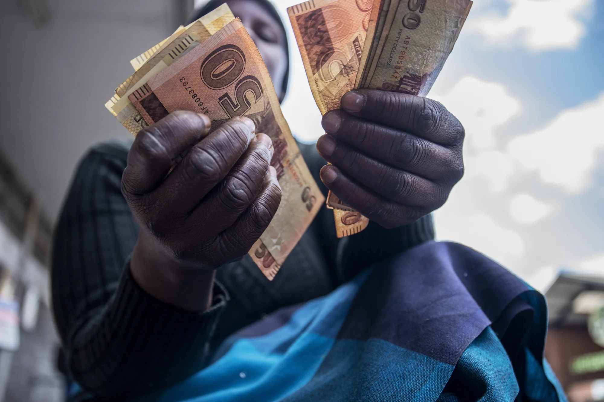 A street vendor counts out Zimbabwean 50 dollar banknotes in&nbsp;Harare, Zimbabwe.