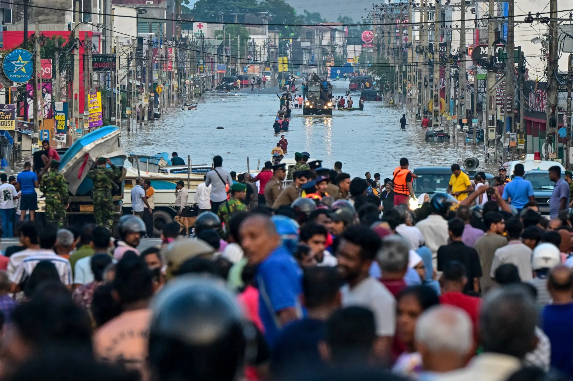 Army personnel rescue stranded people as they wade through a flooded road in Colombo on Nov. 30.