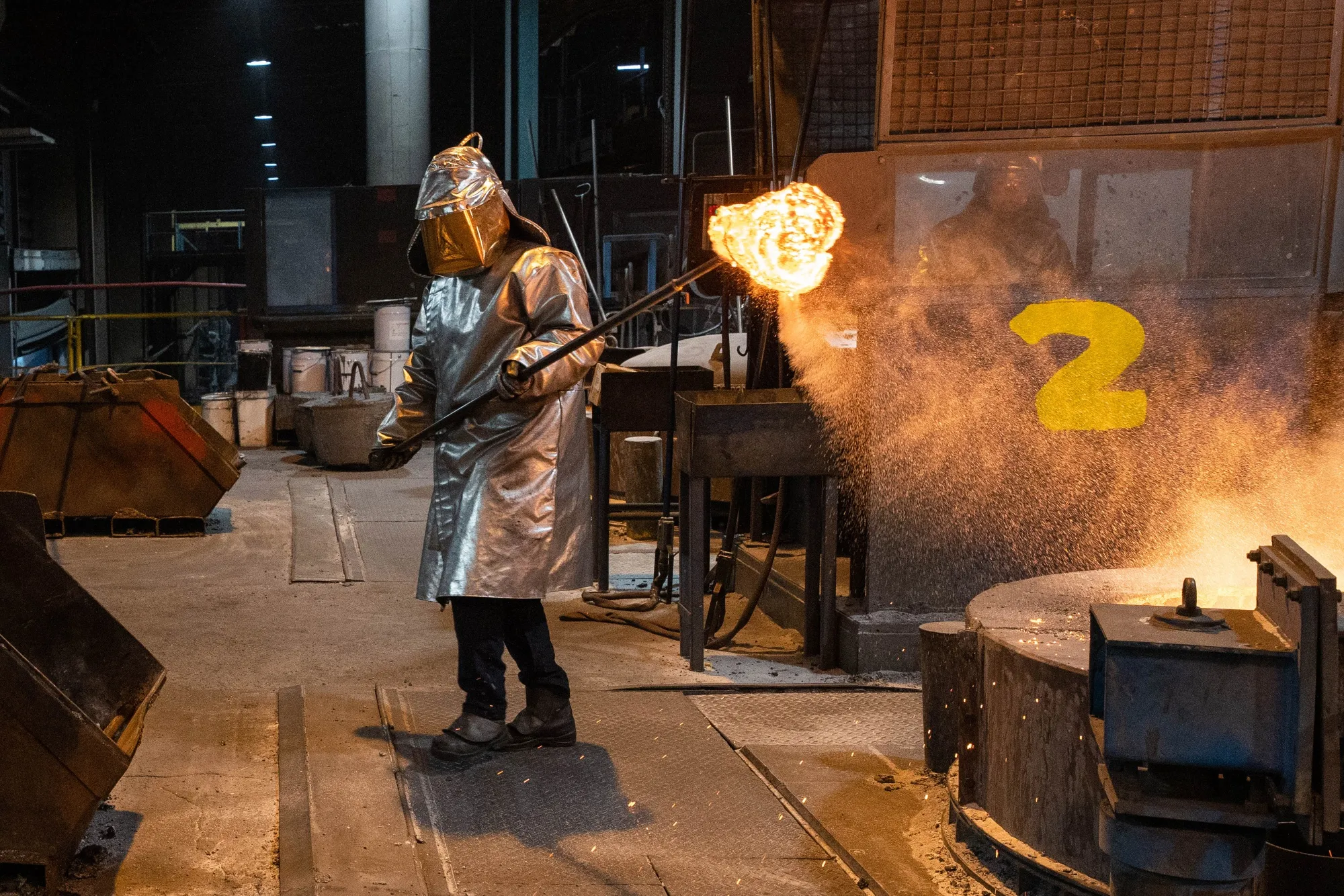 A worker removes a sample from a crucible of molten aluminum in a foundry in Dunkirk, France.