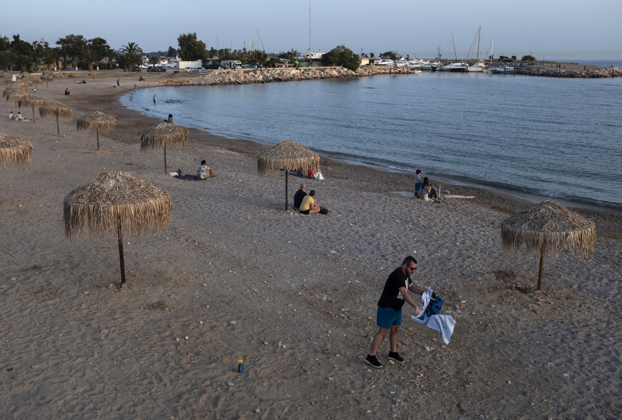 People sit on the beach on the evening in Glyfada, Greece, May 13.