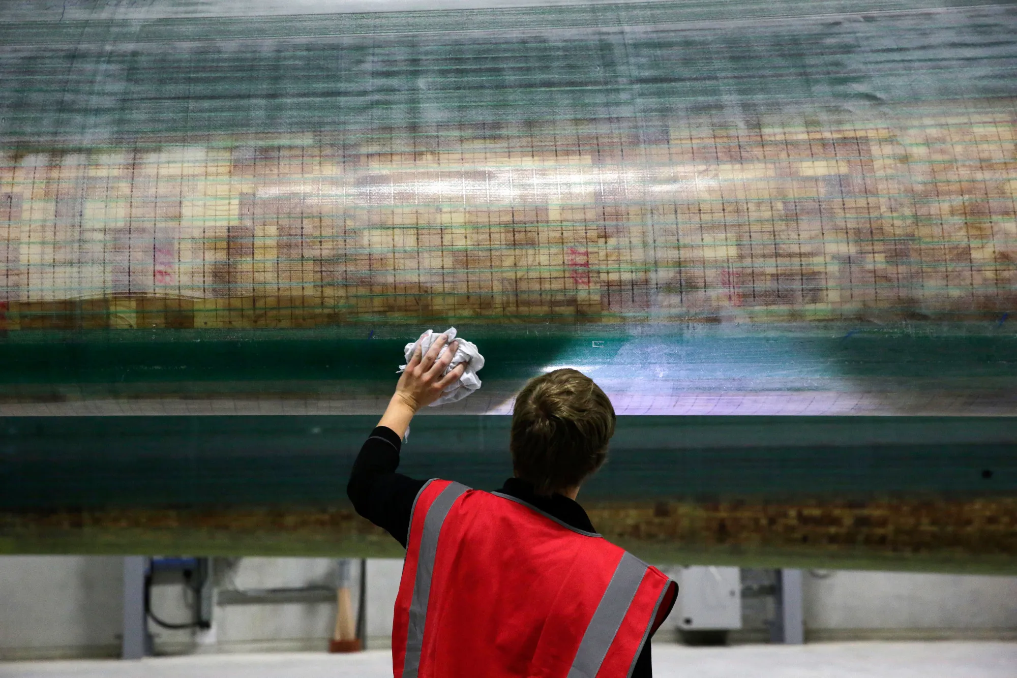 An employee performs quality control checks on a constructed wind turbine blade before it is painted at a production factory in Hull, U.K.