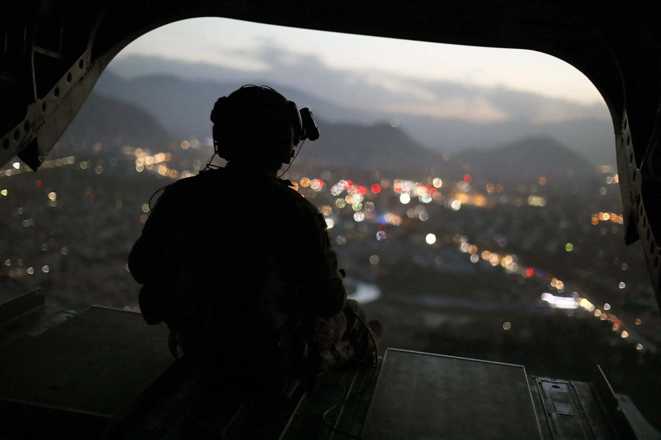 A U.S. Army helicopter crewman mans a gun on the rear gate as it departs Resolute Support headquarters in Kabul.
