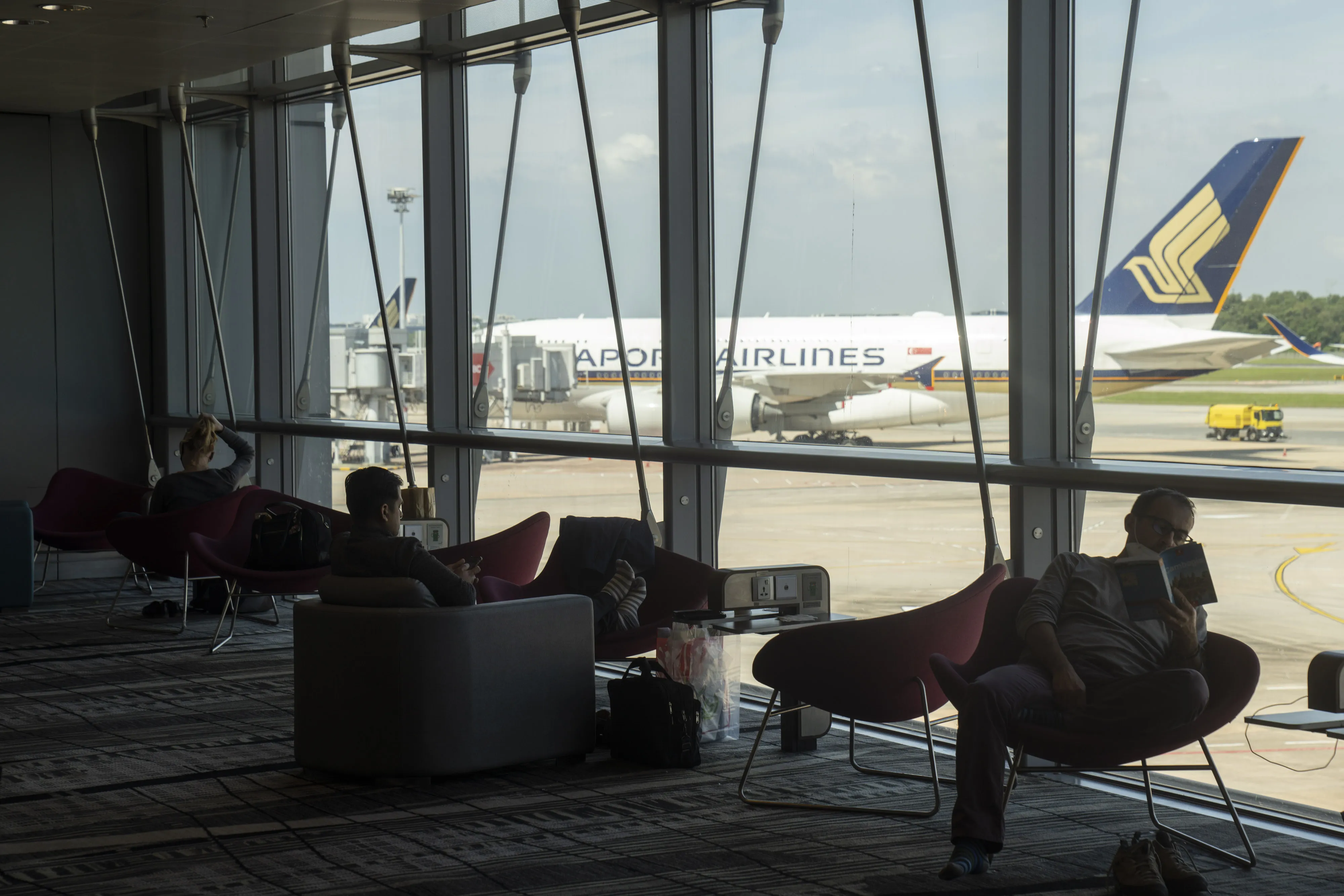 Travelers in a waiting area at Changi Airport in Singapore.