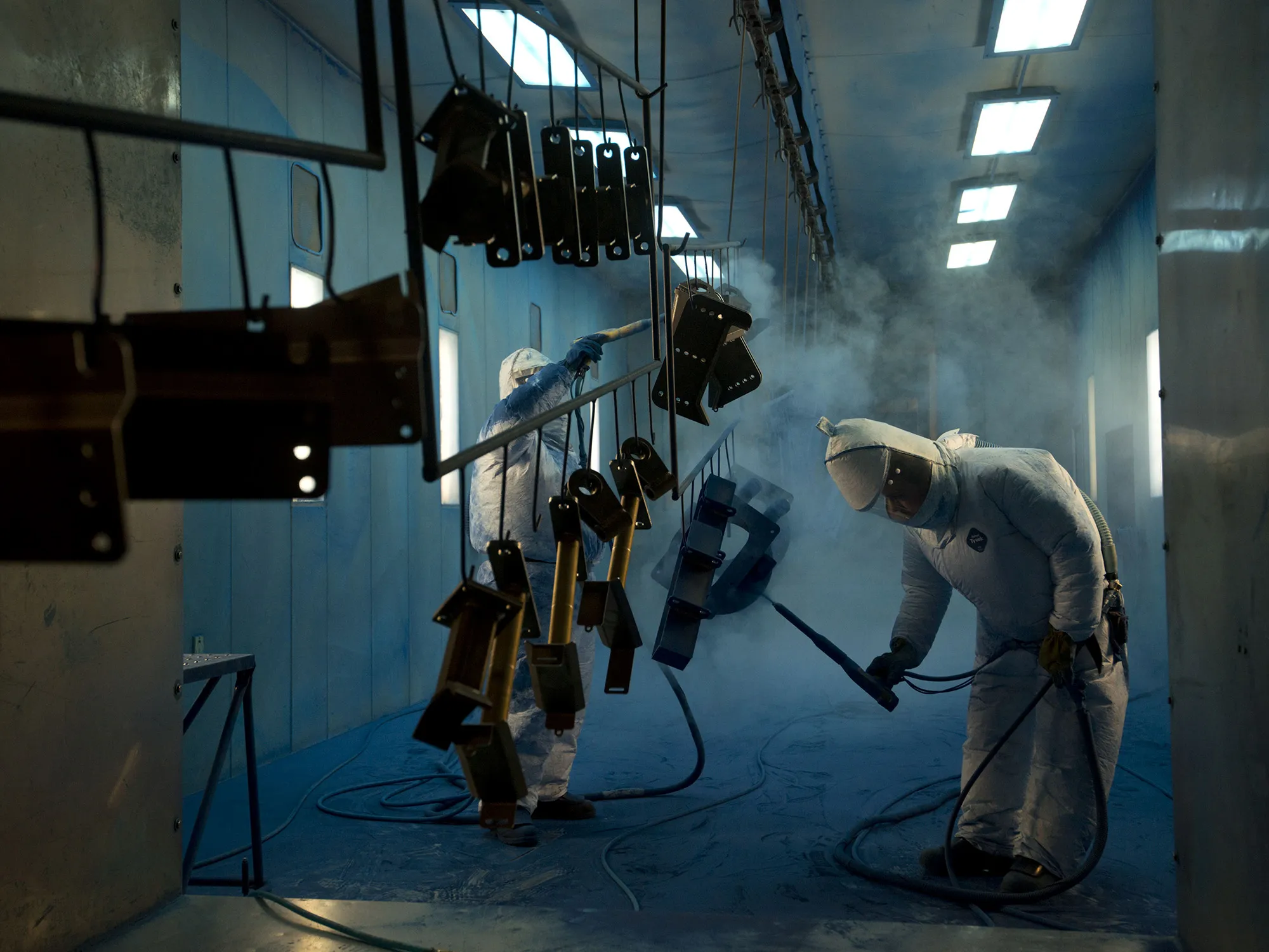 Workers powder-coat components at a facility in Williamsburg, Iowa.