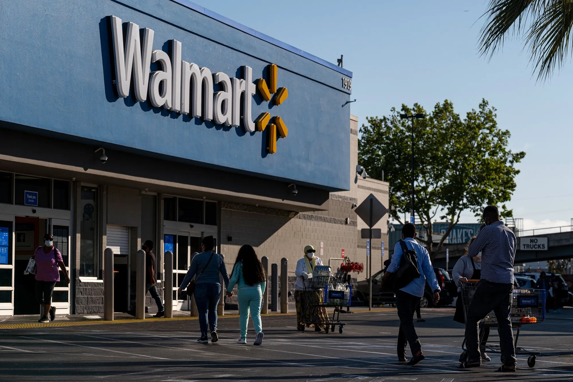 Shoppers walk in front of a Walmart store in San Leandro, California.