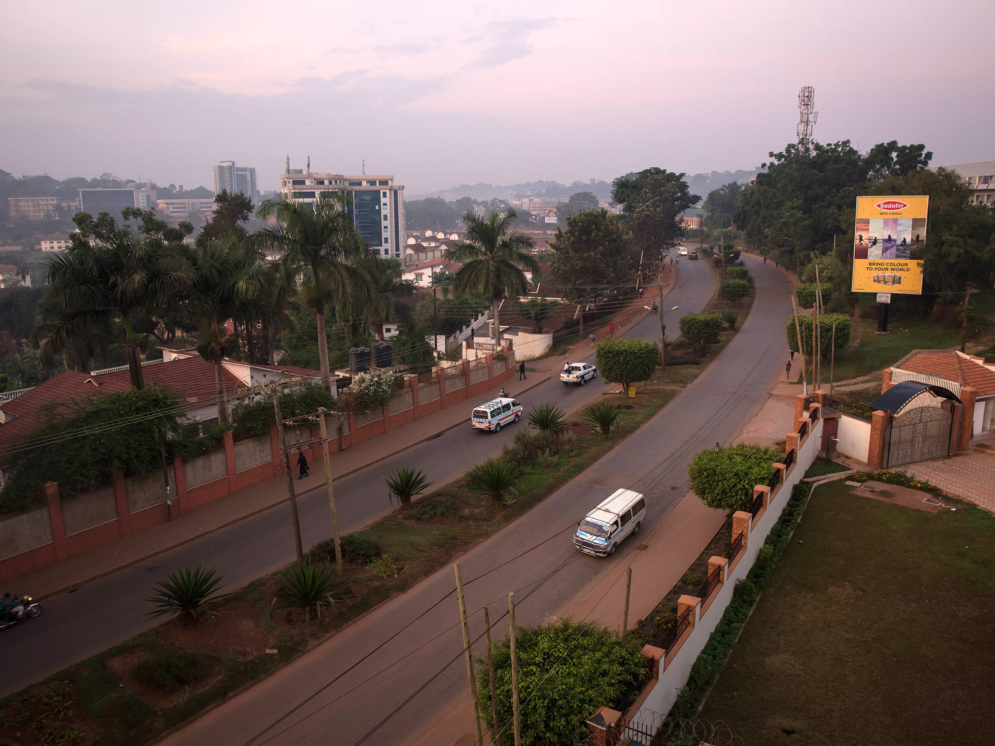 Cars and boda bodas drive along Riga Street, Kampala.