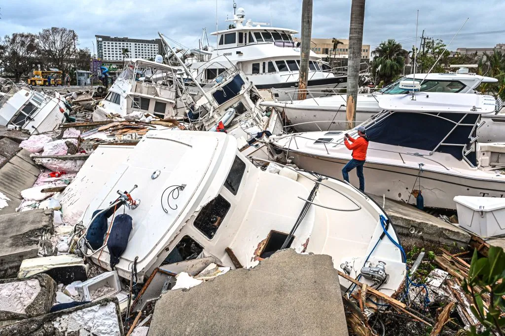 A man takes photos of boats damaged by Hurricane Ian in Fort Myers, Florida, on September 29, 2022.&nbsp;