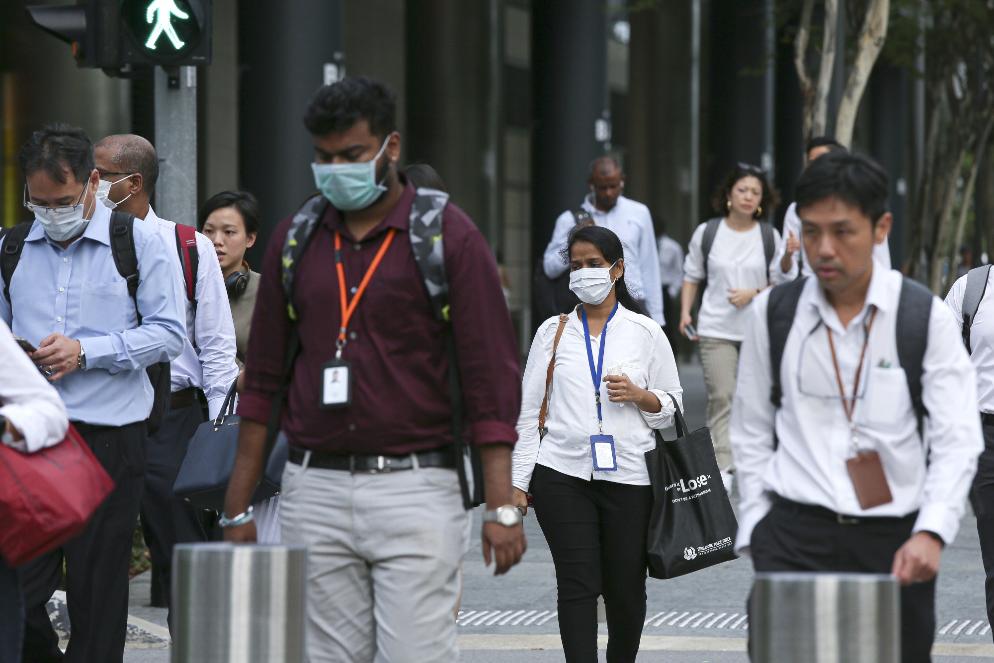 Commuters wear protective masks in the Marina Bay business district of Singapore.