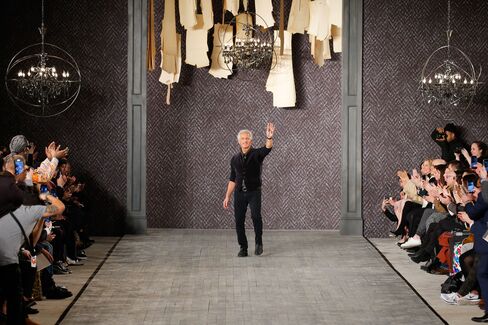 Designer Abboud waves to guests after showing his first runway collection in 15 years.