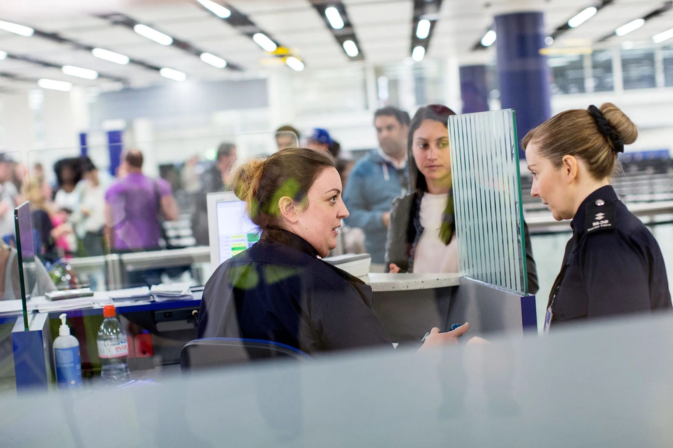Border Force personnel check passports of passengers arriving at Gatwick Airport.

