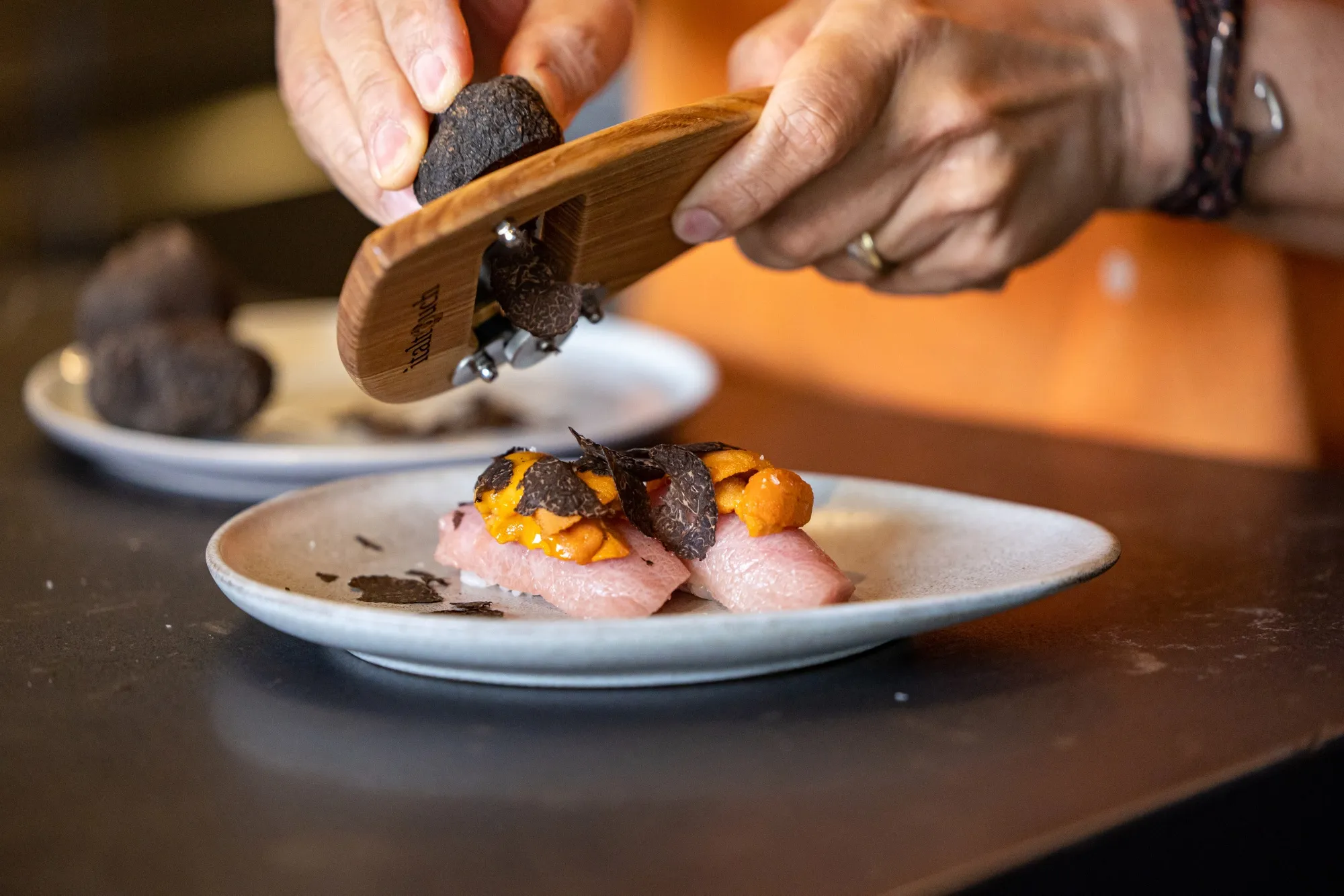 Reif Othman, chef and owner of Reif Japanese Kushiyaki, shaves Italtouch-supplied black truffles on a dish.