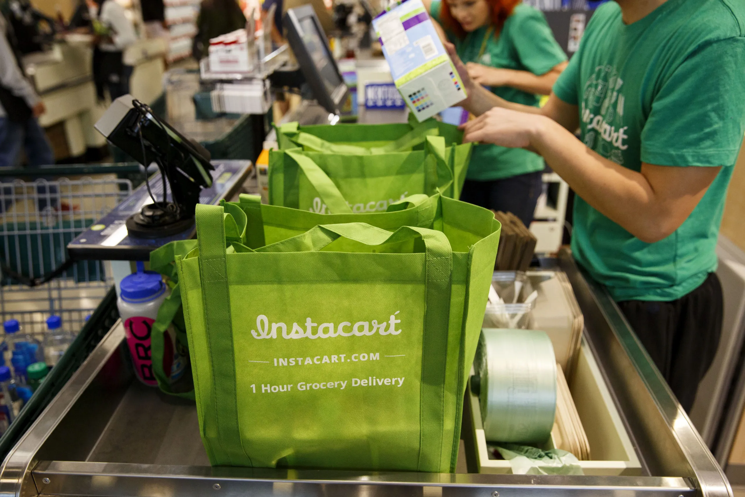InstaCart employees fulfill orders at a Whole Foods store in Los Angeles.