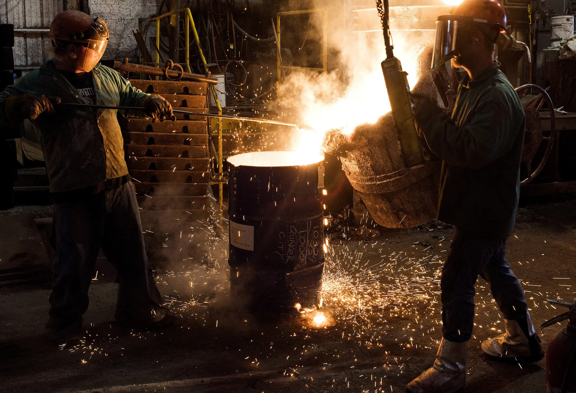 A worker removes slag, a stony waste substance created from the smelting process, from molten metal in a ladle at a castings facility in Salem, Ohio.
