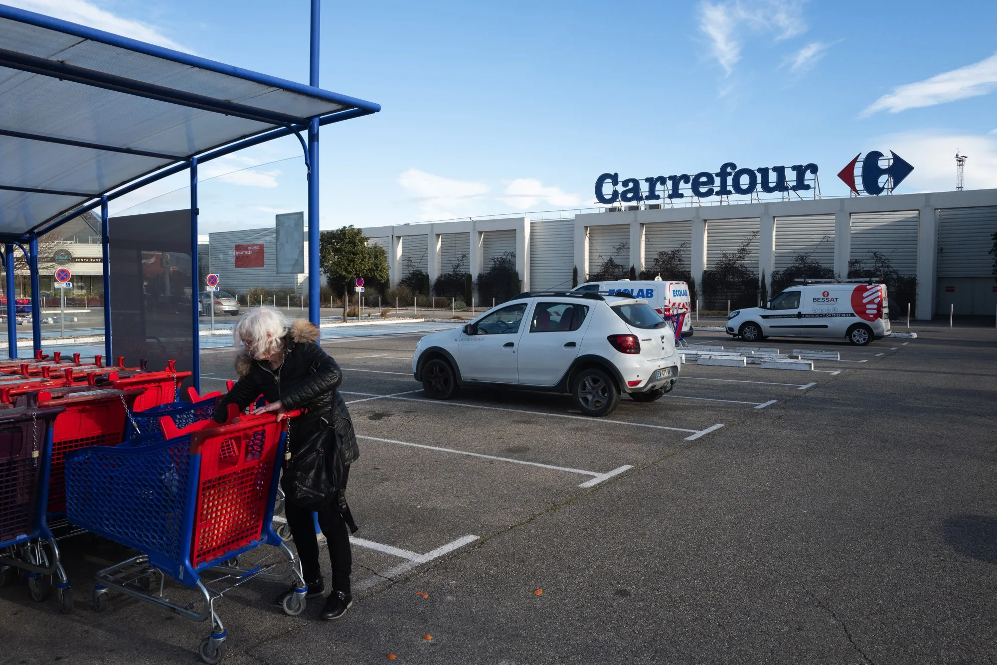 A customer collects a shopping cart outside a Carrefour SA hypermarket in Avignon, France, on Friday, Jan. 15, 2021. Alimentation Couche-Tard Inc. plans to pump 3 billion euros ($3.6 billion) into Carrefour as the Canadian convenience-store operator seeks to defuse mounting French political concerns over the proposed $20 billion takeover of the French retailer.