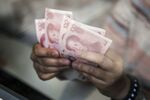 An employee at a currency exchange store counts Chinese one-hundred yuan banknotes in Hong Kong, China.