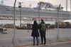 A man and a woman look at the Diamond Princess cruise ship, operated by Carnival Corp., sitting docked in Yokohama, Japan, on Wednesday, Feb. 12, 2020.